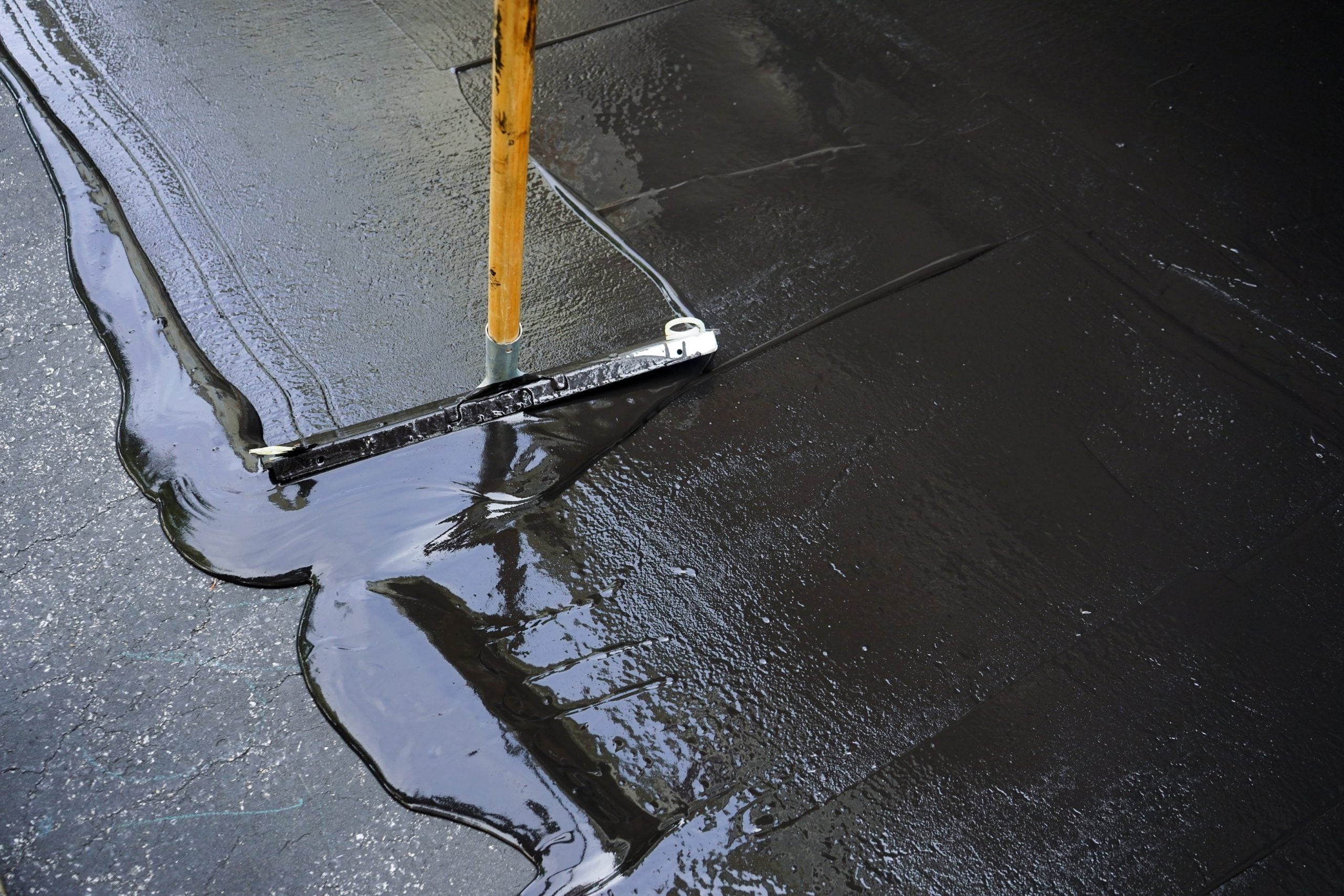 Asphalt Resurfacing Man sealing asphalt driveway/Sealcoating Asphalt Resurfacing
